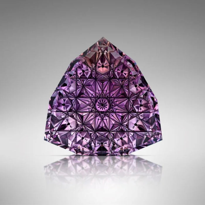Purple diamond on a reflective surface with a gray background